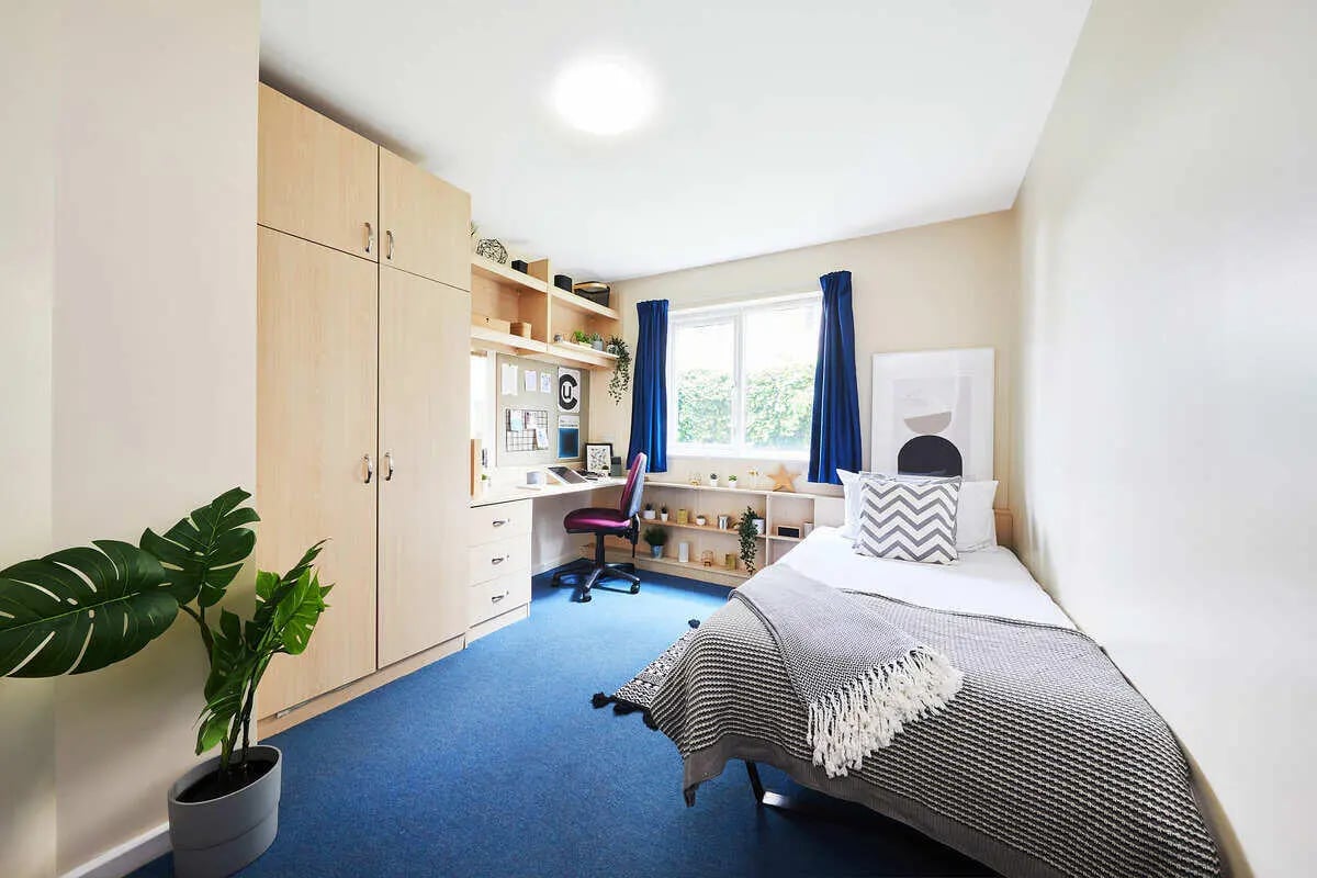 Bed desk wardrobe and plant bedroom interior at Collegiate Upper Quay House in Gloucester Student Accommodation