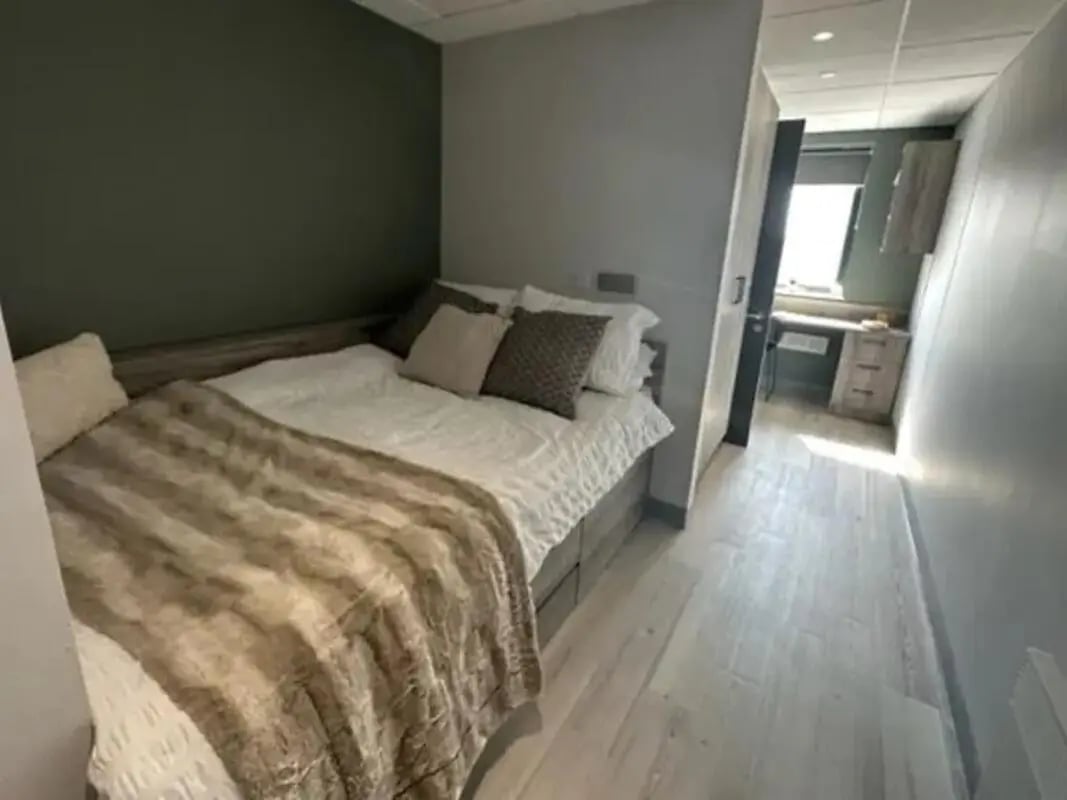 Bed with blanket pillows and desk area bedroom at Crown Place Swansea in Swansea Student Accommodation