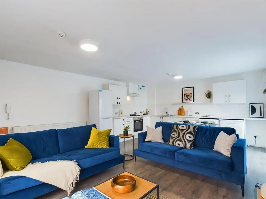 Blue sofas kitchen area living room at 6 Bedroom House at 2, Flat 2, Windsor House, Clint Road West in Liverpool Student Accommodation