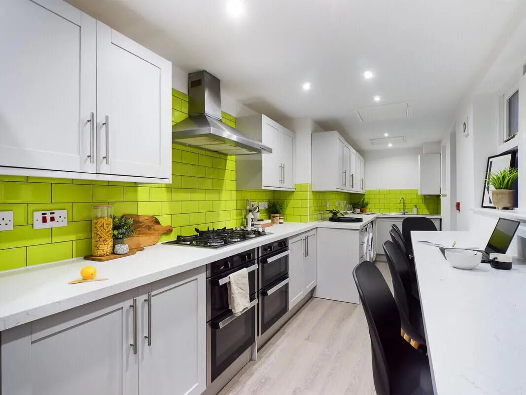 White cabinets green tiles stove ovens dining table kitchen at 8 Bedroom House at 213, Smithdown Road in Liverpool Student Accommodation
