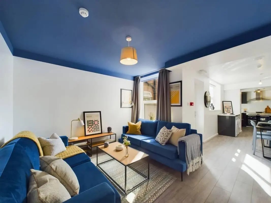 Blue sofas coffee table artwork kitchen living room at 5 Bedroom House at 2, Crofton Street in Manchester Student Accommodation