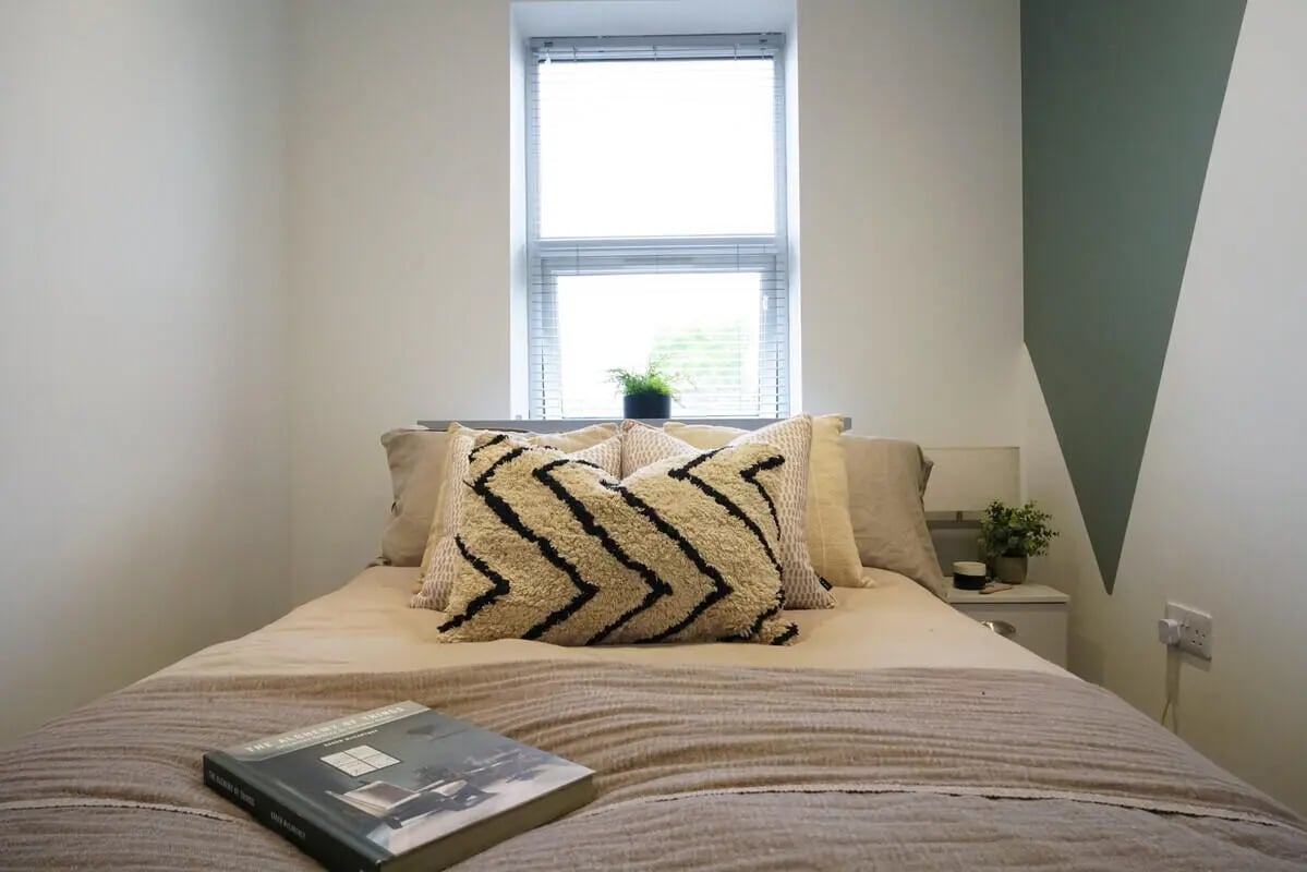 Bed with pillows and book bedroom at 6 Bedroom House at 148, West Parade in Lincoln Student Accommodation