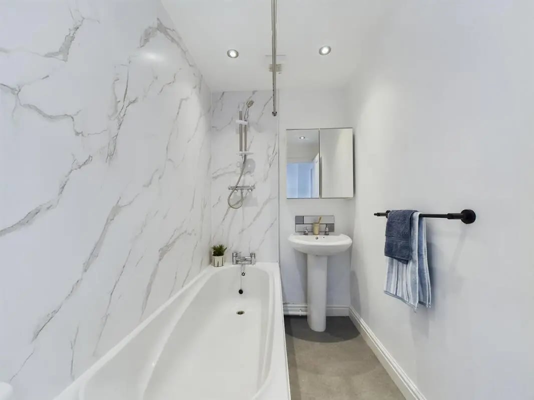 White marble shower bathtub sink and towels bathroom at 6 Bedroom House at 73, West Parade in Lincoln Student Accommodation