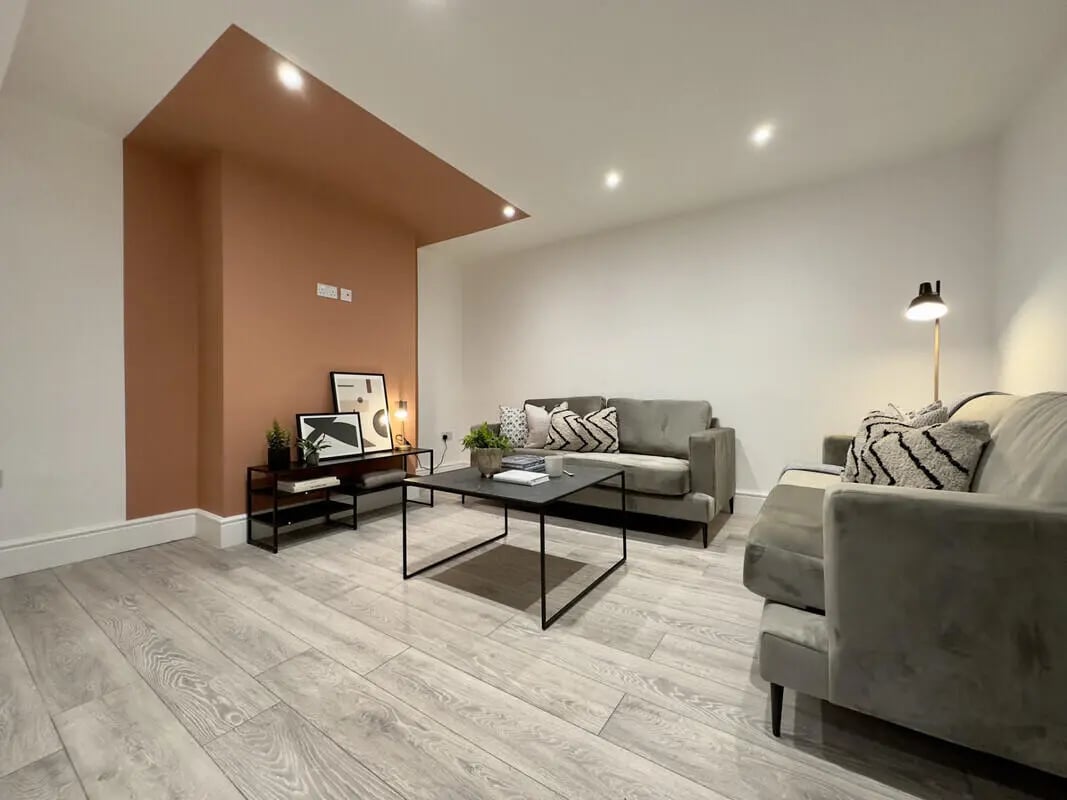 Two grey sofas coffee table and artwork Living room at 6 Bedroom House at 45, Monks Road in Lincoln Student Accommodation