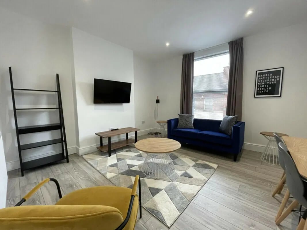 Blue sofa ladder shelf rug coffee table living room at 2 Bedroom House at 20 A, Portland Street in Lincoln Student Accommodation