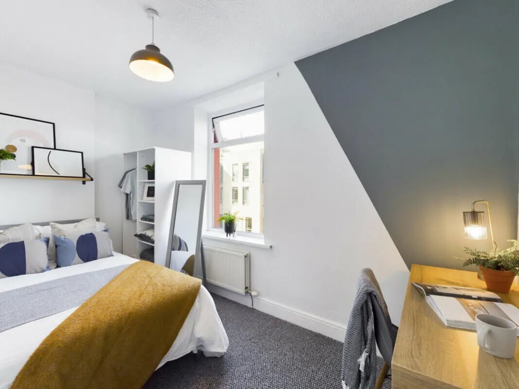 Bed desk shelf mirror and closet bedroom at 5 Bedroom House at 17, Gladstone Terrace in Lancaster Student Accommodation