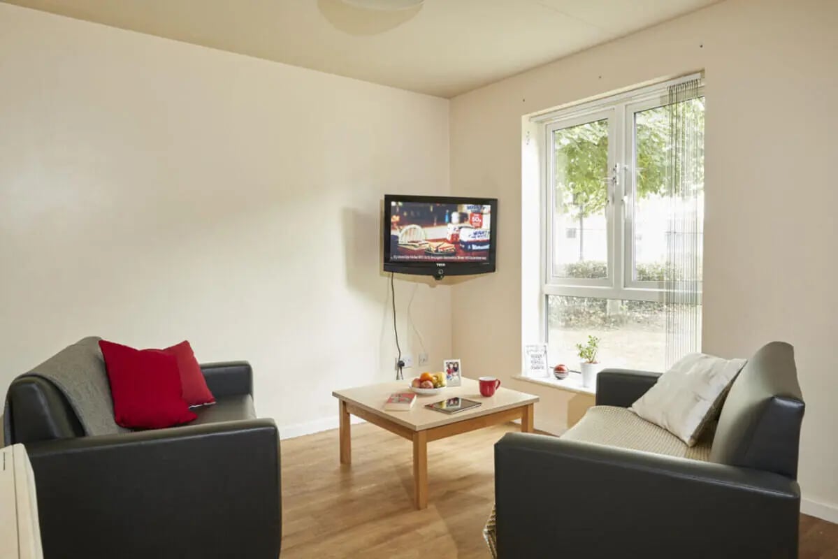 Two black sofas coffee table television living room at 4 Bedroom House at 13, Brookside in Derby Student Accommodation