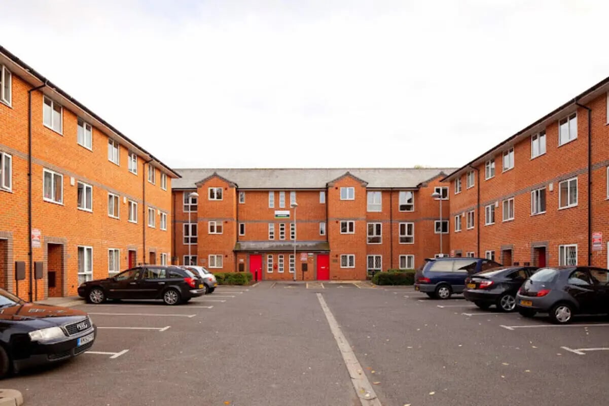Brick building with parked cars exterior at 4 Bedroom House at 15, Brookside in Derby Student Accommodation