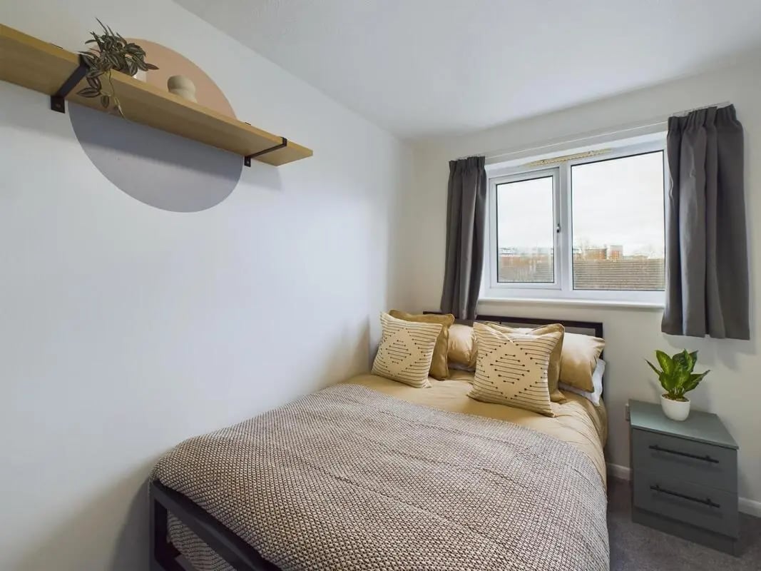 Bed with pillows nightstand plant bedroom at 6 Bedroom House at 1, Mint Road in Leicester Student Accommodation
