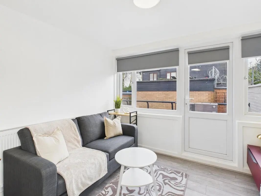 Grey sofa white tables and patterned rug Living room at 2 Bedroom House at Flat 1, Grove Street Studios, The Groves in Liverpool Student Accommodation
