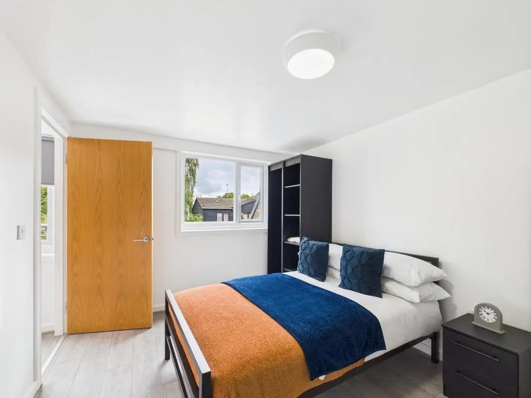 Bed blue blanket orange throw black closet bedroom at 1 Bedroom House at Flat 4, Grove Street Studios, The Groves in Liverpool Student Accommodation