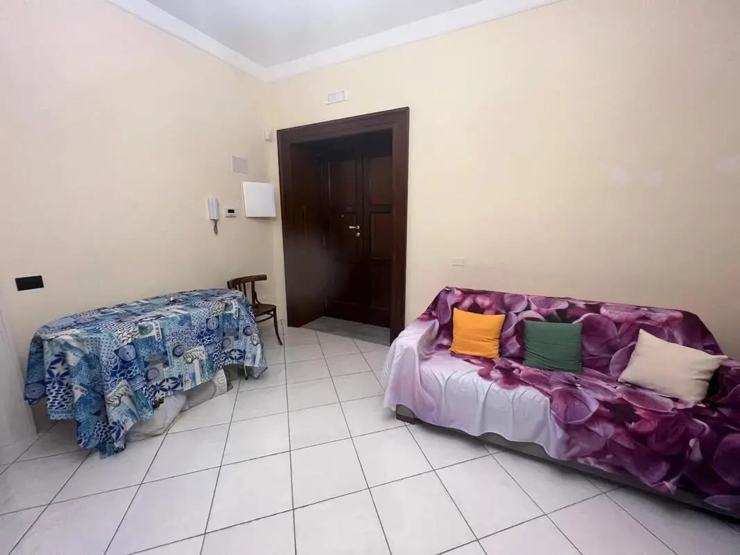 Sofa with patterned throw and pillows living room at Appartamento di due stanze in Sant'Agnello Student Accommodation