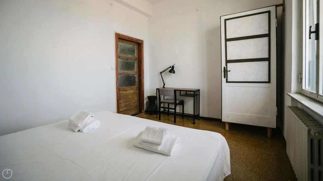 Bed desk lamp chair white door bedroom at Welcoming 2-bedroom apartment near the Albenga train station in Albenga Student Accommodation