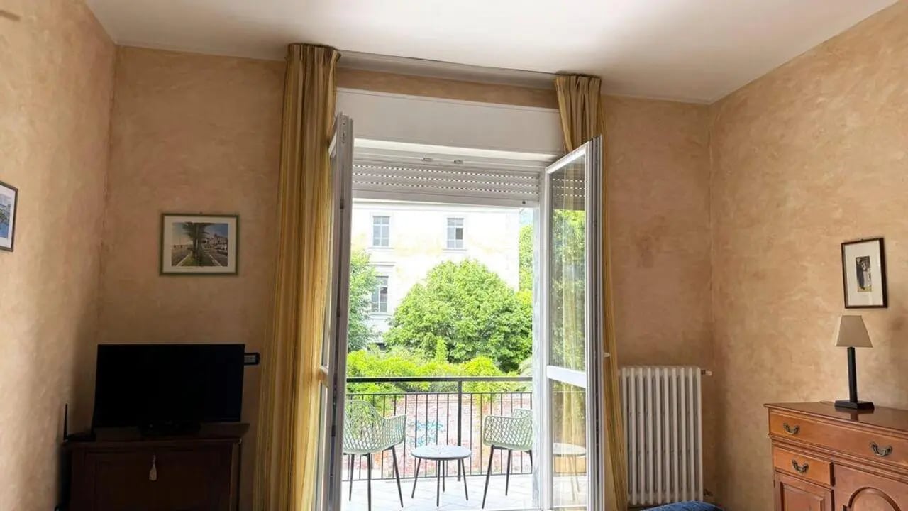 Television radiator dresser curtains balcony view bedroom at Tasteful 1-bedroom apartment in Albenga in Albenga Student Accommodation