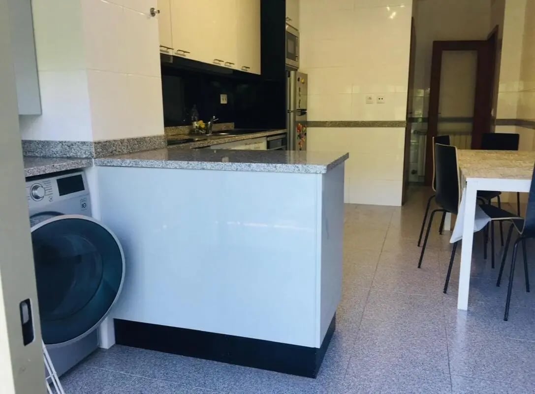 Washing machine and kitchen counter dining table kitchen at Exclusive 2 Bedroom Apartment with a balcony close to Minho University in Guimaraes Student Accommodation