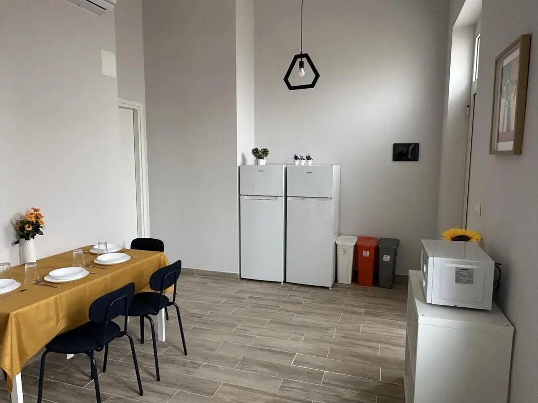 Dining table chairs refrigerators microwaves trash cans kitchen at Amazing single room in Pescara in Pescara Student Accommodation