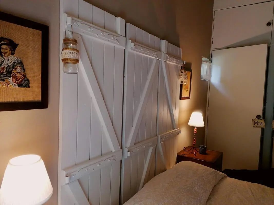 White barn door headboard lamps and framed art bedroom at Charming and serene country house in Sopo, Vila Nova de Cerveira in Viana Do Castelo Student Accommodation