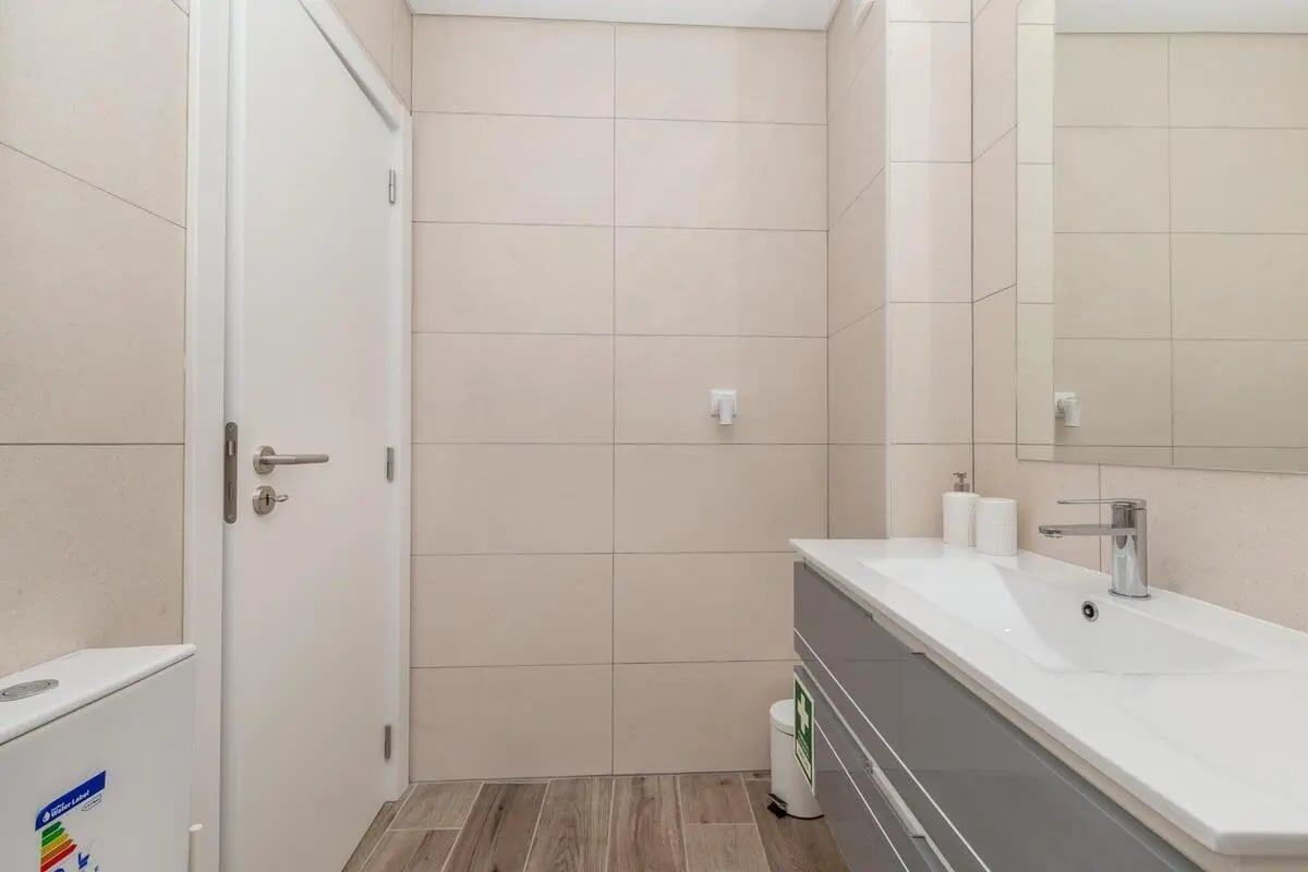 Door toilet vanity sink and mirror bathroom at Neat 2-bedroom flat in Olhão in Faro Student Accommodation