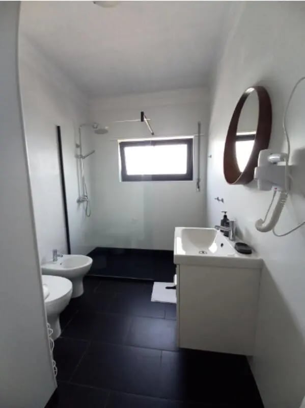 Two toilets sink shower mirror hairdryer bathroom at Nice Twin Bedroom close to City Park of Viana do Castelo in Viana Do Castelo Student Accommodation