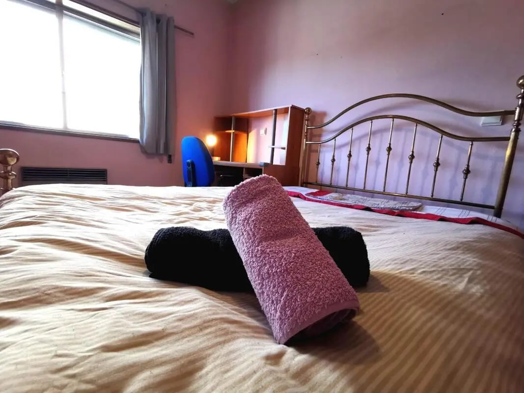 Bed with towels desk chair and window Bedroom at Double Bedroom close to Minho University 7 in Guimaraes Student Accommodation