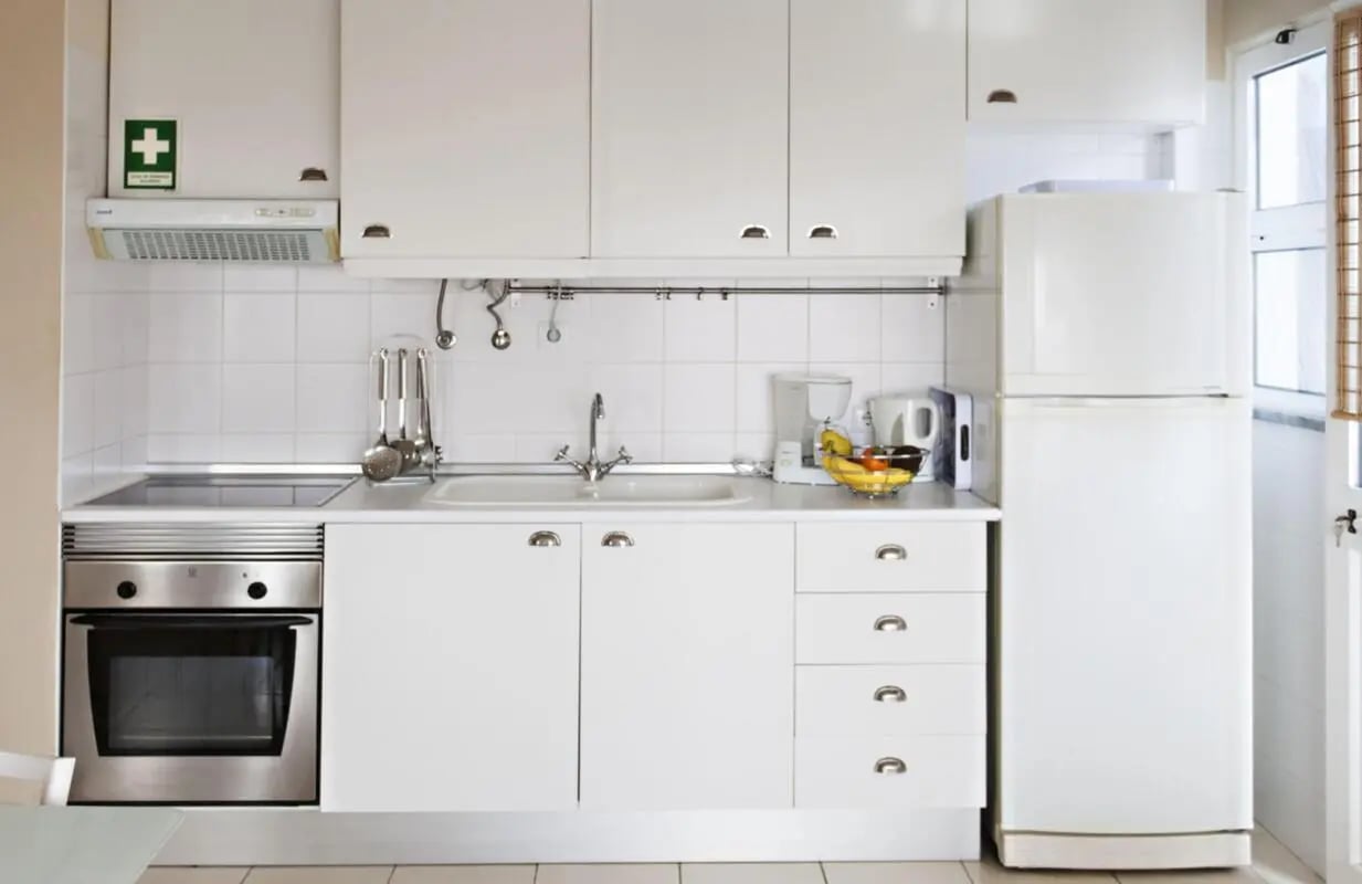 White cabinets oven sink and refrigerator kitchen at Sunny and lovely 1-bedroom flat in Faro Student Accommodation