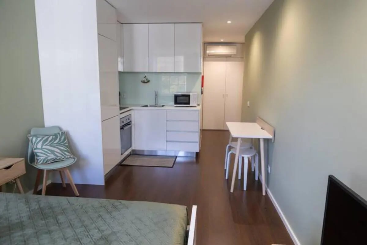 Compact kitchen with table and chair living room at Elegant and functional studio in the historic center of Guimarães in Guimaraes Student Accommodation