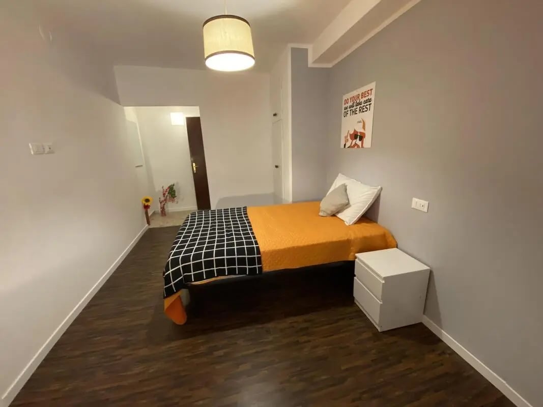 Bed with orange blanket and nightstand bedroom at Comfy double bedroom in the heart of Pescara in Pescara Student Accommodation