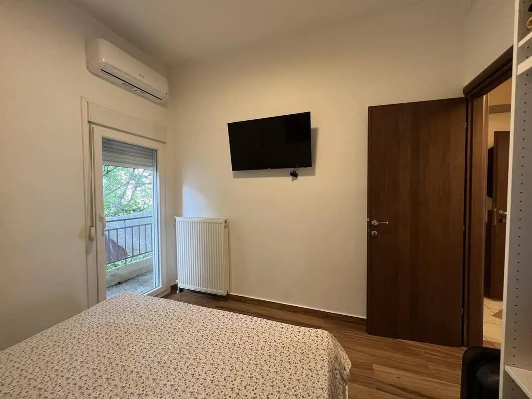 Bed air conditioner radiator television room at Homely Double Bedroom with a balcony close to Aristotelous Square in Thessaloniki Student Accommodation