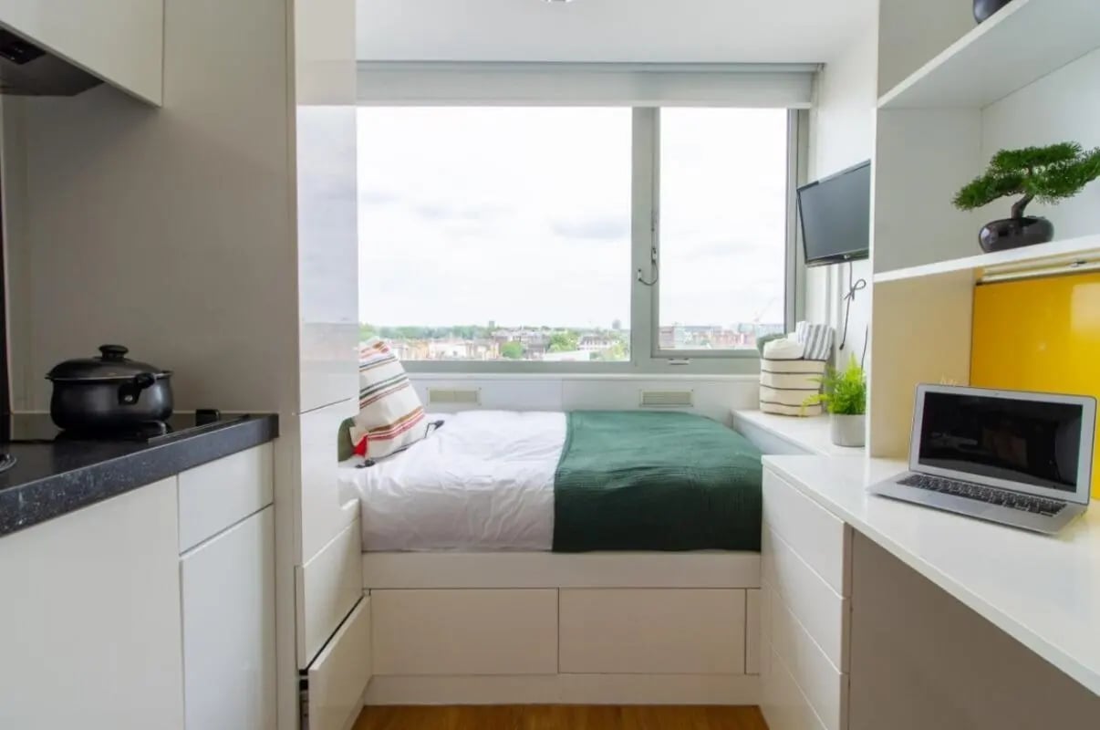 Bed kitchen counter laptop and window studio apartment at Chelsea Lightfoot Hall in London Student Accommodation