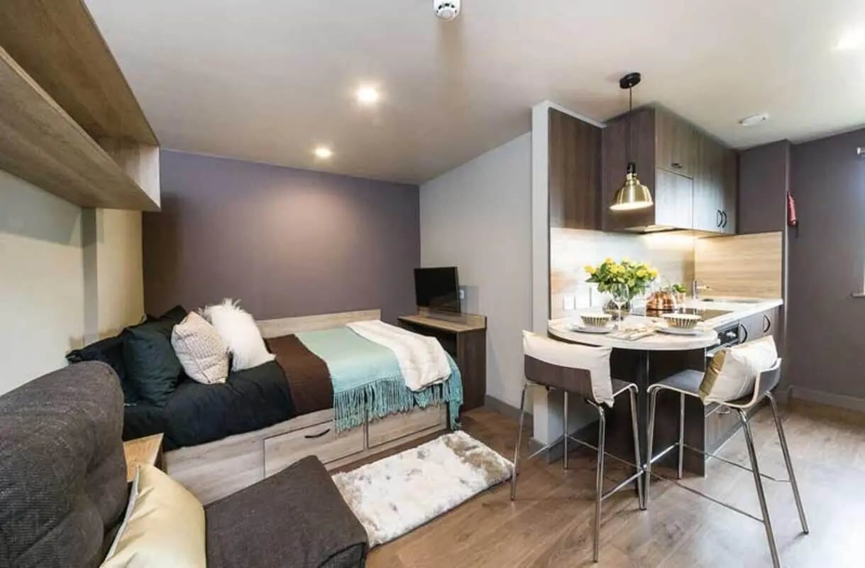 Bed kitchen dining table with stools living area bedroom. at Ernest Place in Durham Student Accommodation