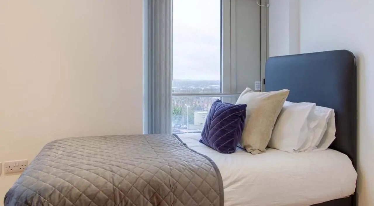 Bed with grey quilted cover and pillows bedroom at Orbital in Nottingham Student Accommodation