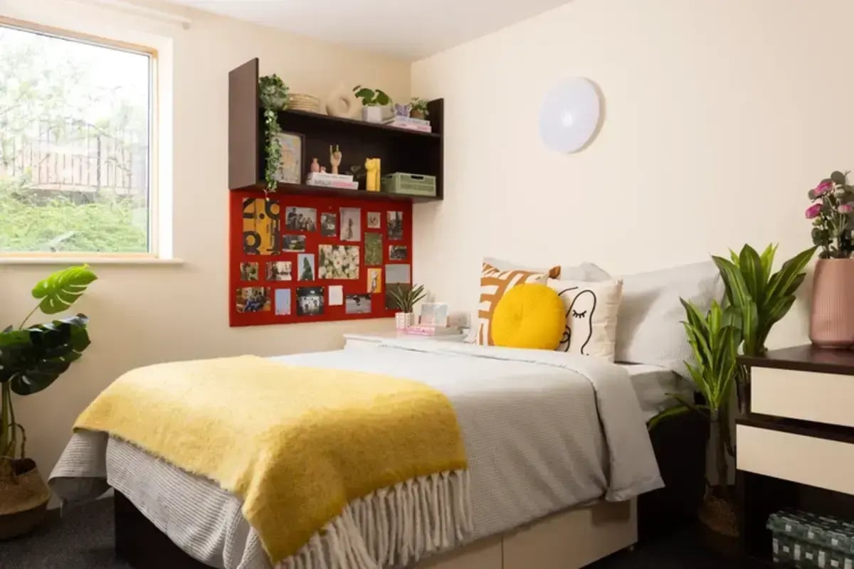 Bed with yellow blanket and photos bedroom at Byron Central in Newcastle Upon Tyne Student Accommodation