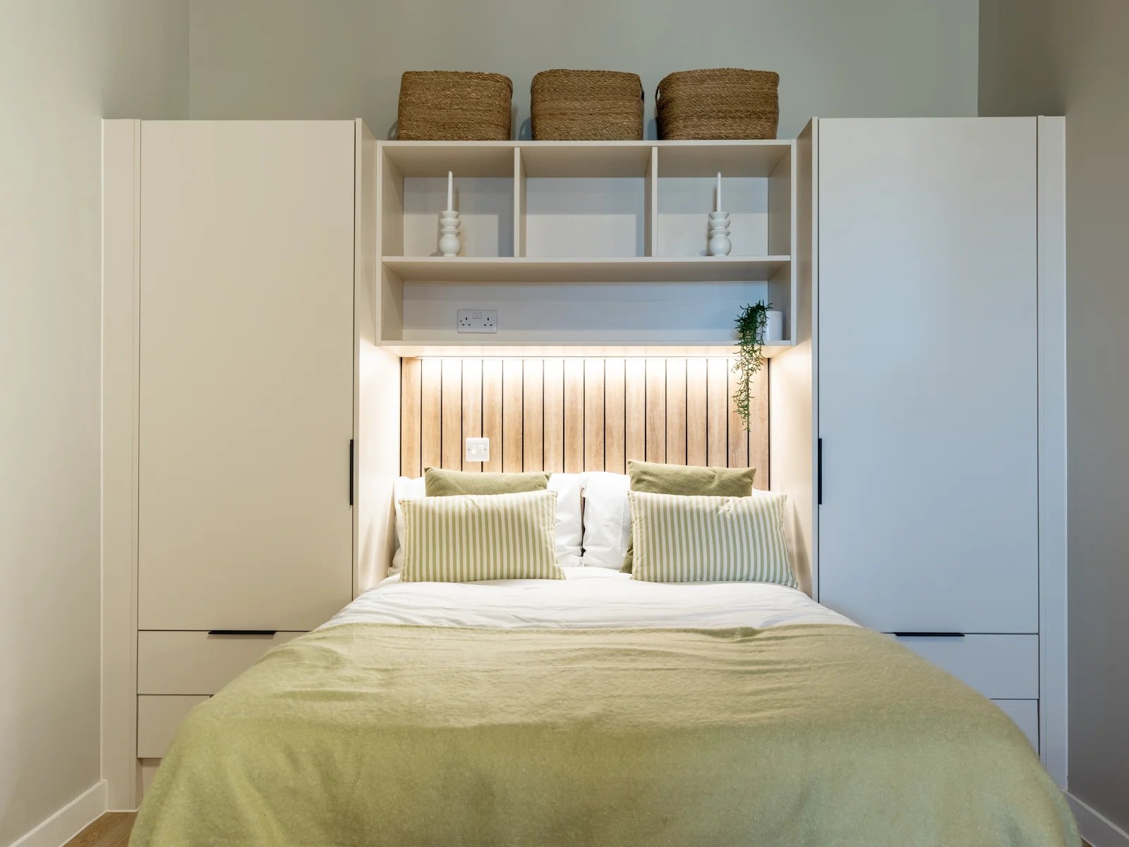 Bed with striped pillows and built-in wardrobe bedroom at Fitz and Knox in Cardiff Student Accommodation