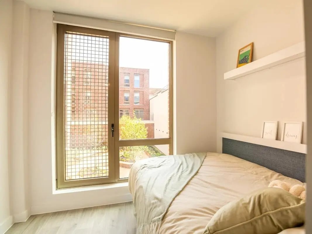 Bed with mint throw framed art and two framed pictures Bedroom at Promenade Student Living in Brighton Student Accommodation