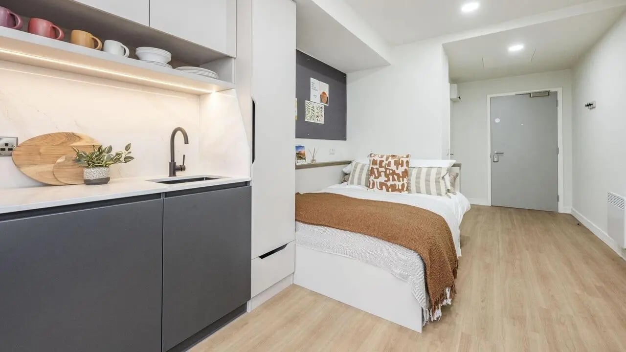 Kitchen counter bed with pillows and throw bedroom at Broadway Studios in Glasgow Student Accommodation