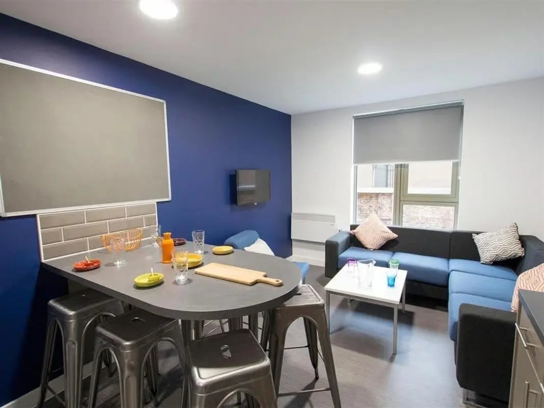 Dining table with stools sofa and coffee table living room at Foundry Courtyard in Glasgow Student Accommodation