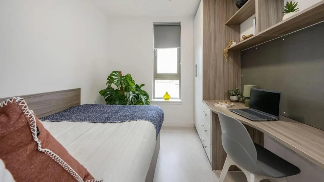 Bed desk and laptop with plant bedroom at Foundry Courtyard in Glasgow Student Accommodation