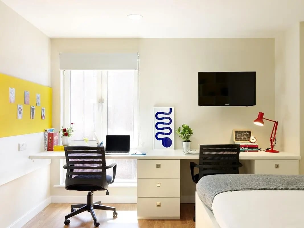 Two desks chairs laptop TV study area bedroom at Student Castle York in York Student Accommodation
