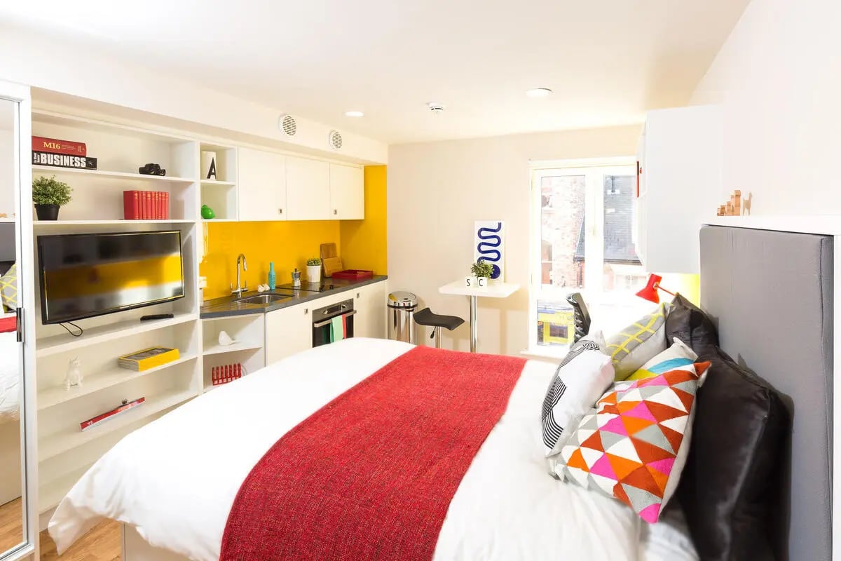 Bed kitchenette shelves TV and table bedroom at Student Castle York in York Student Accommodation