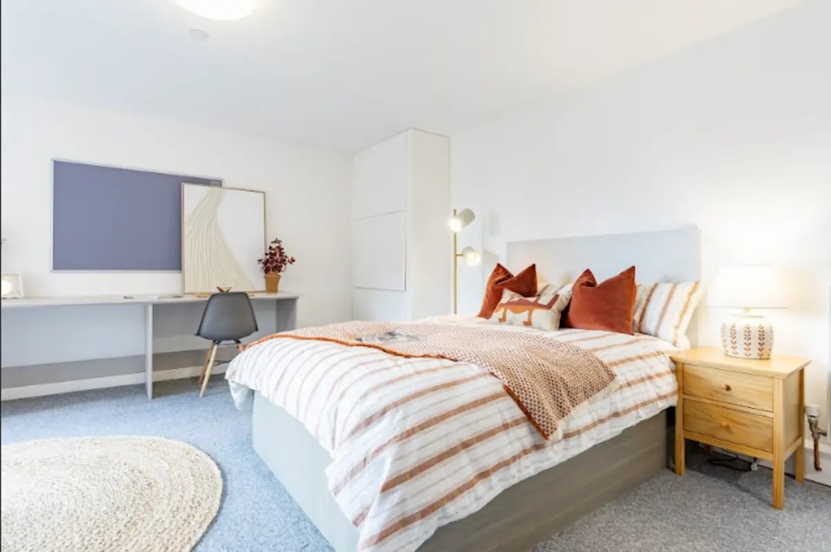 Bed desk chair artwork rug and bedside lamp bedroom at Radford Mill in Nottingham Student Accommodation