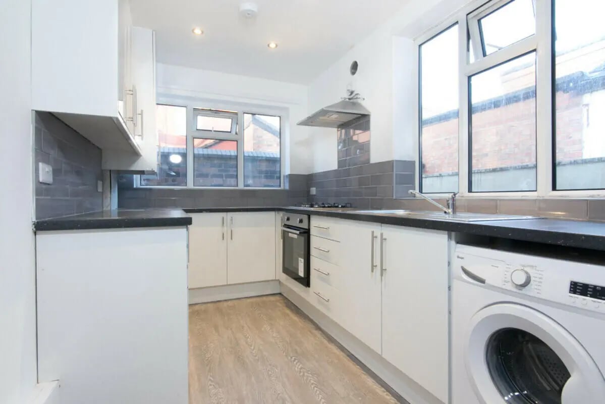 White cabinets stove oven and washing machine kitchen at 3 Bedroom House at 93, Gerald Road in Salford Student Accommodation