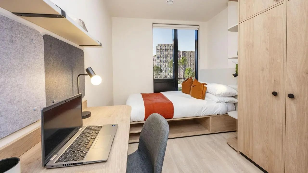 Bed desk lamp wardrobe and bed bedroom at Press House in London Student Accommodation