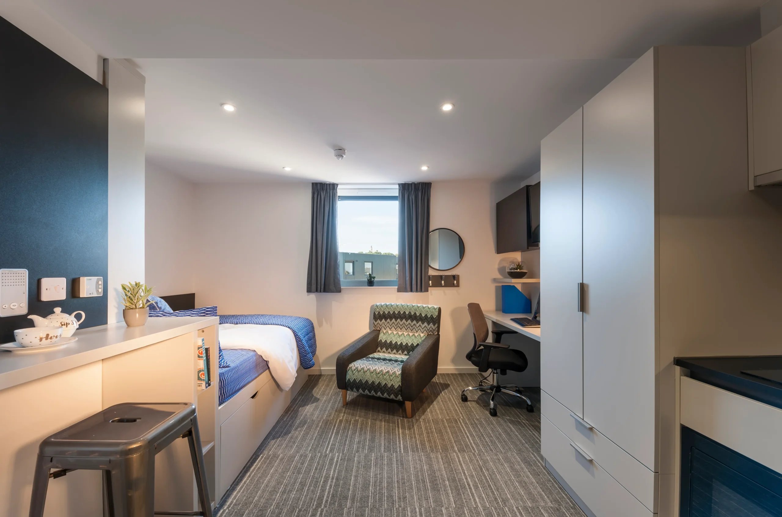 Bed desk chair wardrobe and study area at New Park in Edinburgh Student Accommodation