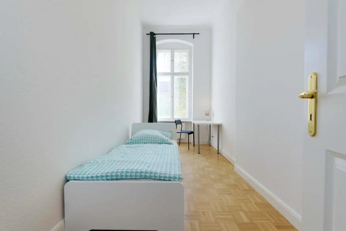 Bed desk chair window green curtain bedroom at Hohenzollerndamm 53.6 in Berlin Student Accommodation