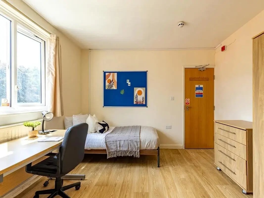 Bed desk chair and dresser bedroom at Brooke Hall in London Student Accommodation