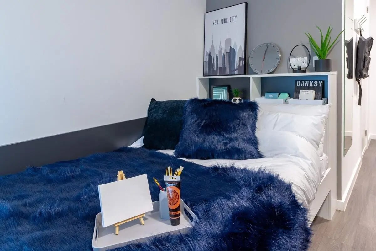Bed with blue fluffy throw and easel bedroom at Pavilion Court London in Wembley Student Accommodation