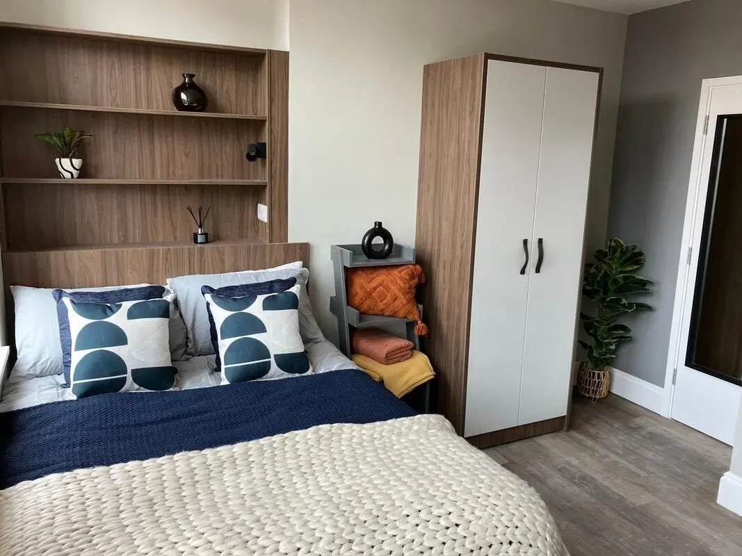 Bed pillows blankets shelves wardrobe and plant bedroom at Chamberlain Place in Birmingham Student Accommodation
