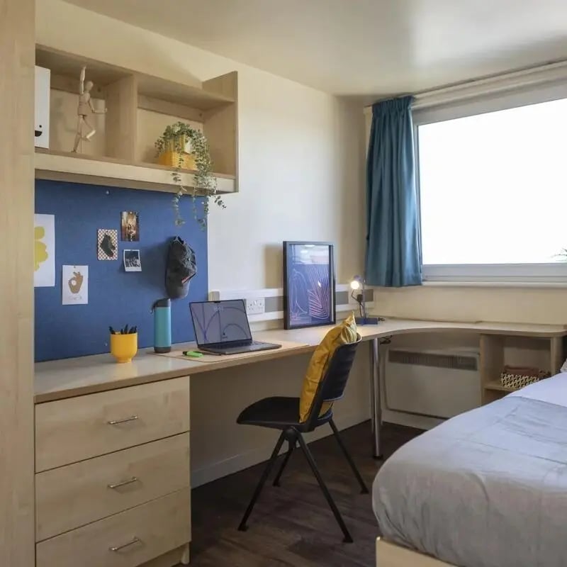 Desk with laptop and bed bedroom study area at Burley Road in Leeds Student Accommodation