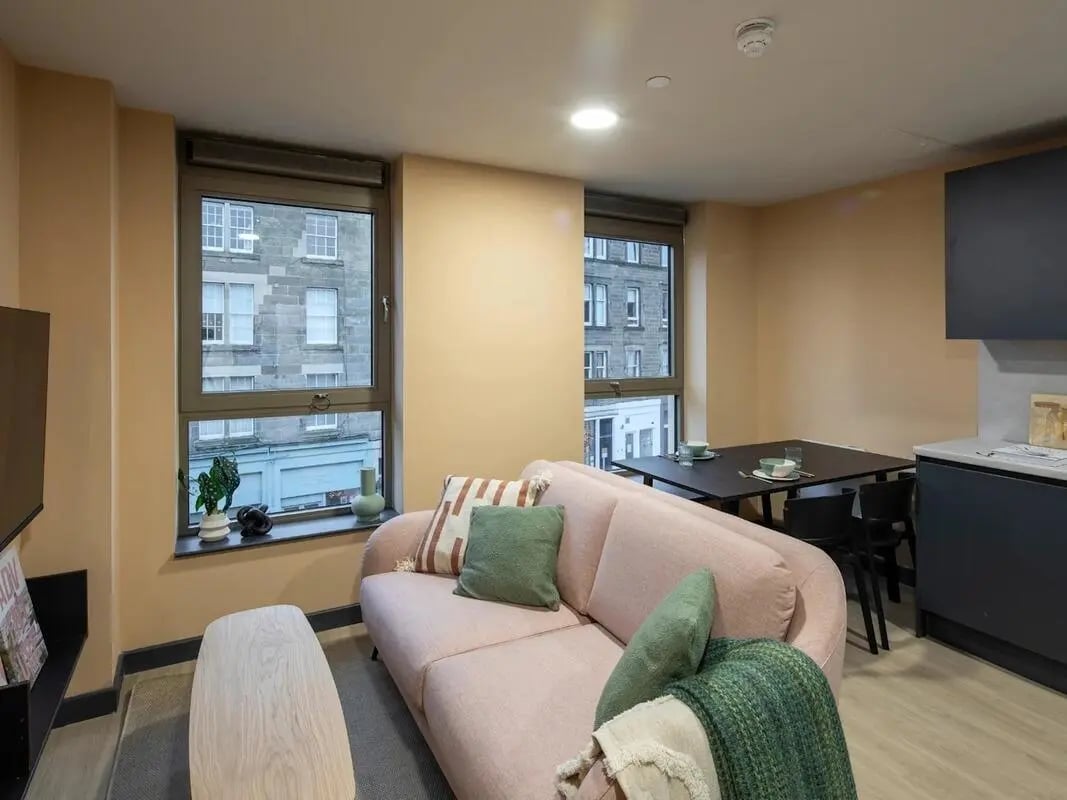 Pink sofa with pillows and blanket living room at Norton's Student Living in Edinburgh Student Accommodation