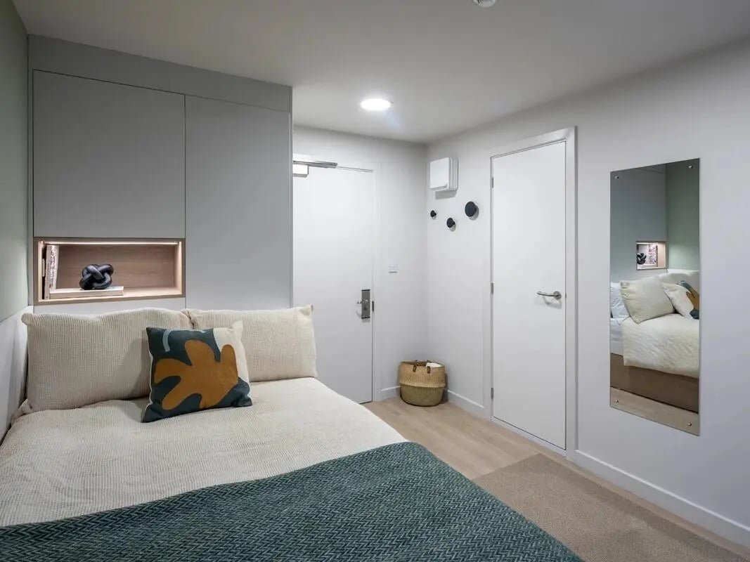 Bed with pillows shelving and doors bedroom at Norton's Student Living in Edinburgh Student Accommodation